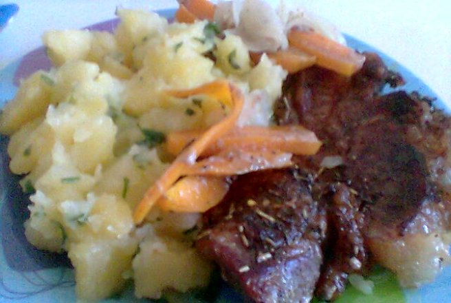 Friptura de porc pe pat de ceapa si morcovi cu cartofi natur