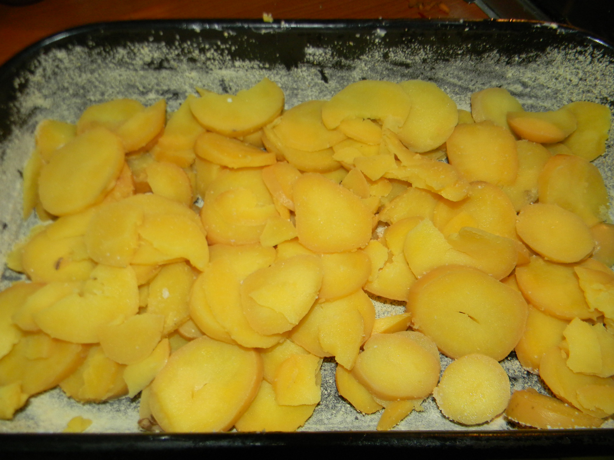 Cartofi cu carnati si smantana la cuptor